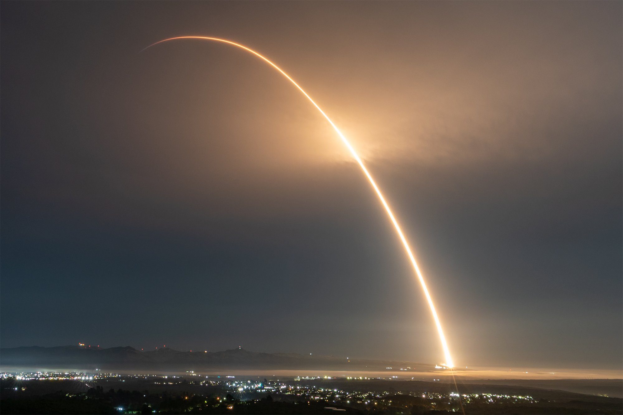 Long exposure of a Falcon 9 carrying an Alba cluster arcing into orbit